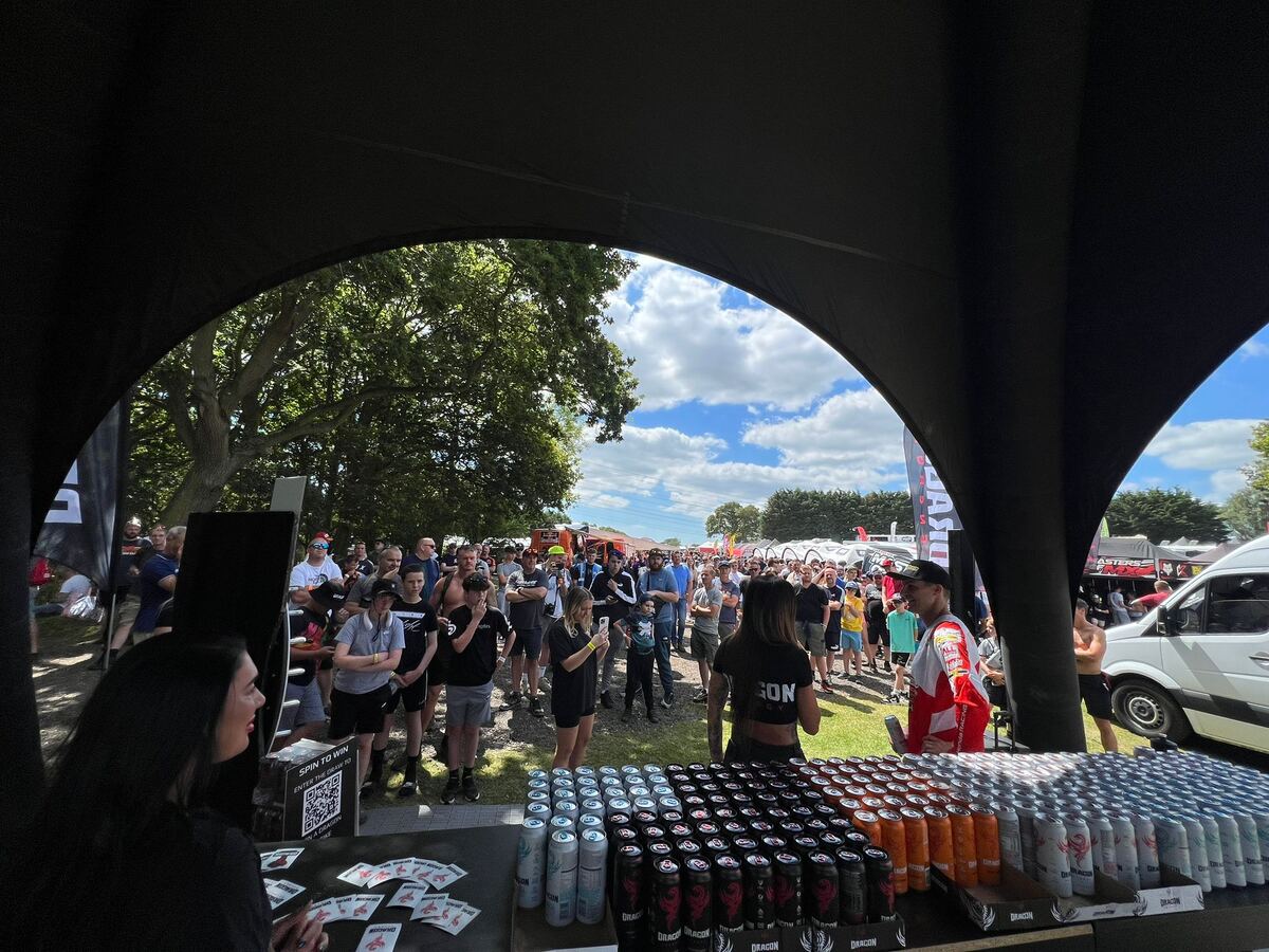 Dragon Energy sampling activation — crowds gathered around the branded tent with cans on display