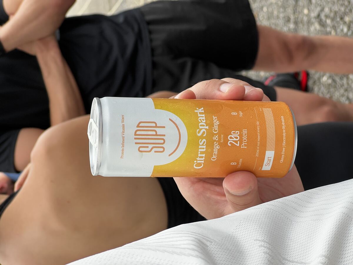 SUPP Citrus Spark Orange and Ginger protein can held up at the Padel X event