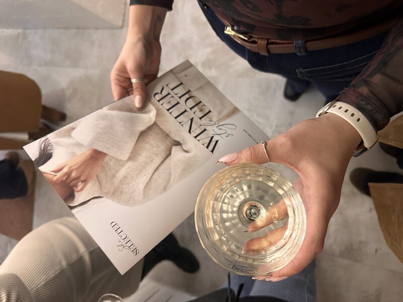 She Selected event — guest with wine and brochure